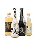 Four Korean liquor bottles arranged together on a plain white background: a clear bottle with pale golden liquid and a black label, a white bottle with a black label and hanging tag, a dark black bottle with a black label, and a pale yellow-green bottle with a green floral label.