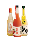 Three bottles of Korean liquor arranged side by side on a plain white background. The left bottle has a light golden-amber liquid and an orange label with Korean text; the center bottle has a pink-red liquid and a white label with red text and fruit imagery; the right bottle has a pale yellow-amber liquid, a black cap, and a yellow label with black fruit illustrations.